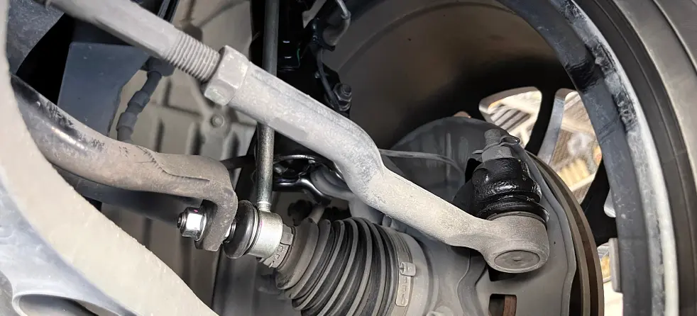 Close-up view of a car's brake system and suspension components, highlighting steering and suspension details.