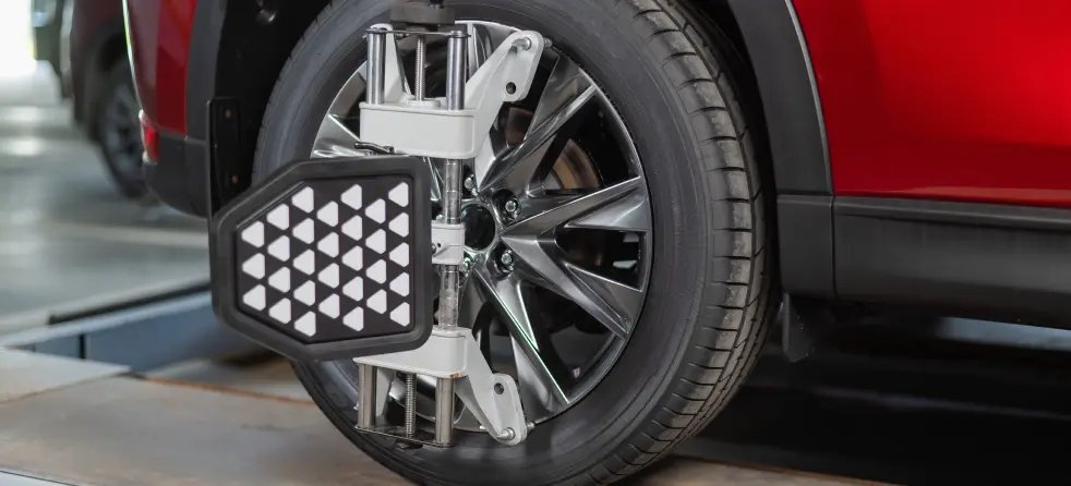 Testing a car tire on a machine, emphasizing wheel alignment accuracy and tire resilience.