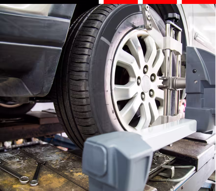 wheel alignment, auto repair in Milwaukee, WI at Next Level Auto Services. A red vehicle undergoing a wheel alignment service