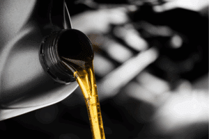 car fluid maintenance, auto repair in Milwaukee, WI at Next Level Auto Services. Close-up image of motor oil being poured from a container, representing routine maintenance to keep engines protected, clean, and efficient.