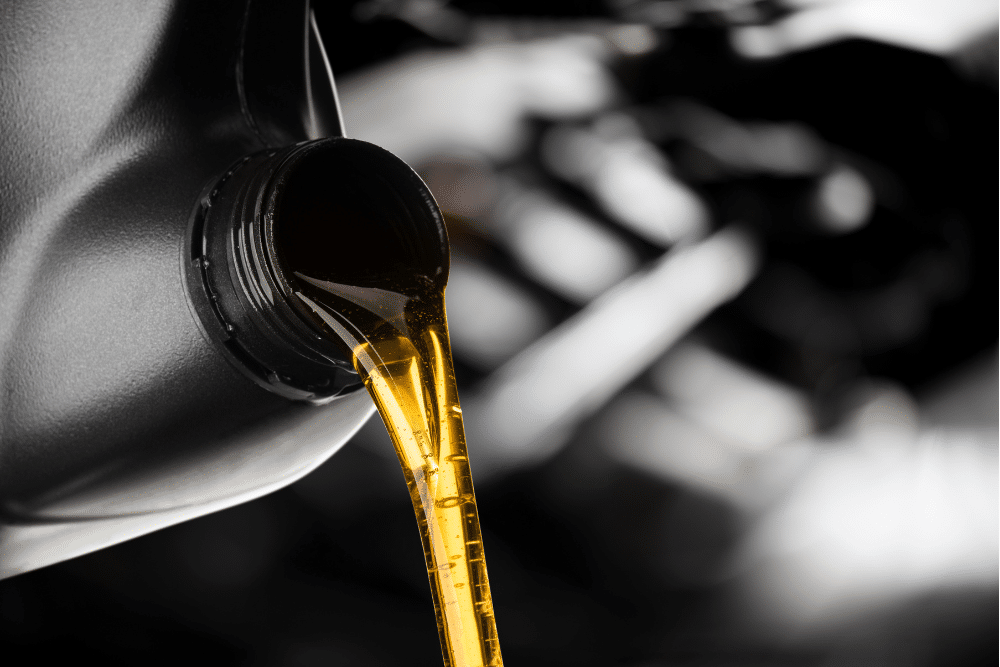 car fluid maintenance, auto repair in Milwaukee, WI at Next Level Auto Services. Close-up image of motor oil being poured from a container, representing routine maintenance to keep engines protected, clean, and efficient.