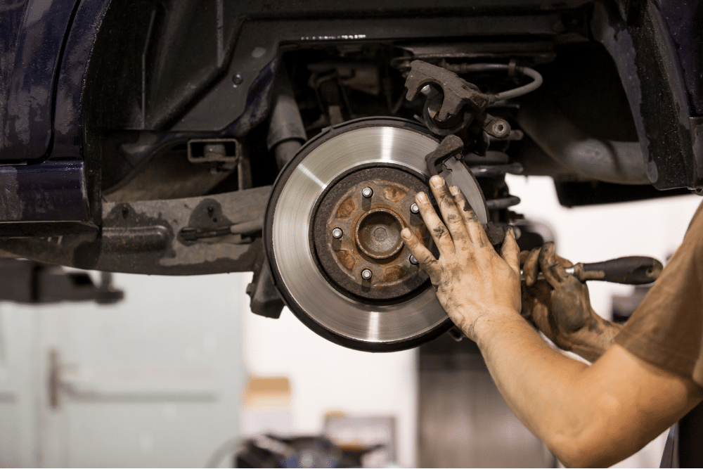 Brake repair in Milwaukee, WI by Next Level Auto Services. Underside view of a car showing suspension components, coil spring, and tire, representing trusted brake diagnostics and repair service.