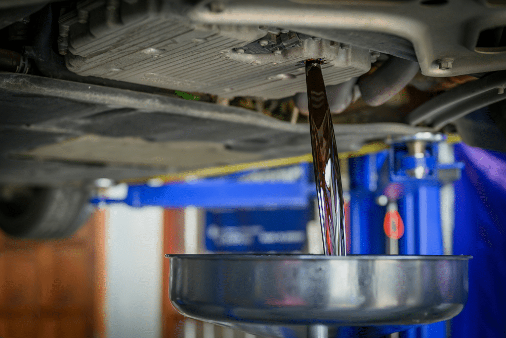 Transmission Fluid Service in Milwaukee WI At Next Level Auto Services. Mechanic draining old transmission fluid during a service in Milwaukee